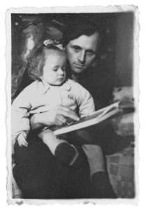 Su knyga ant tėvelio kelių. 1957–1958 m. Prano Skabeikio nuotr.