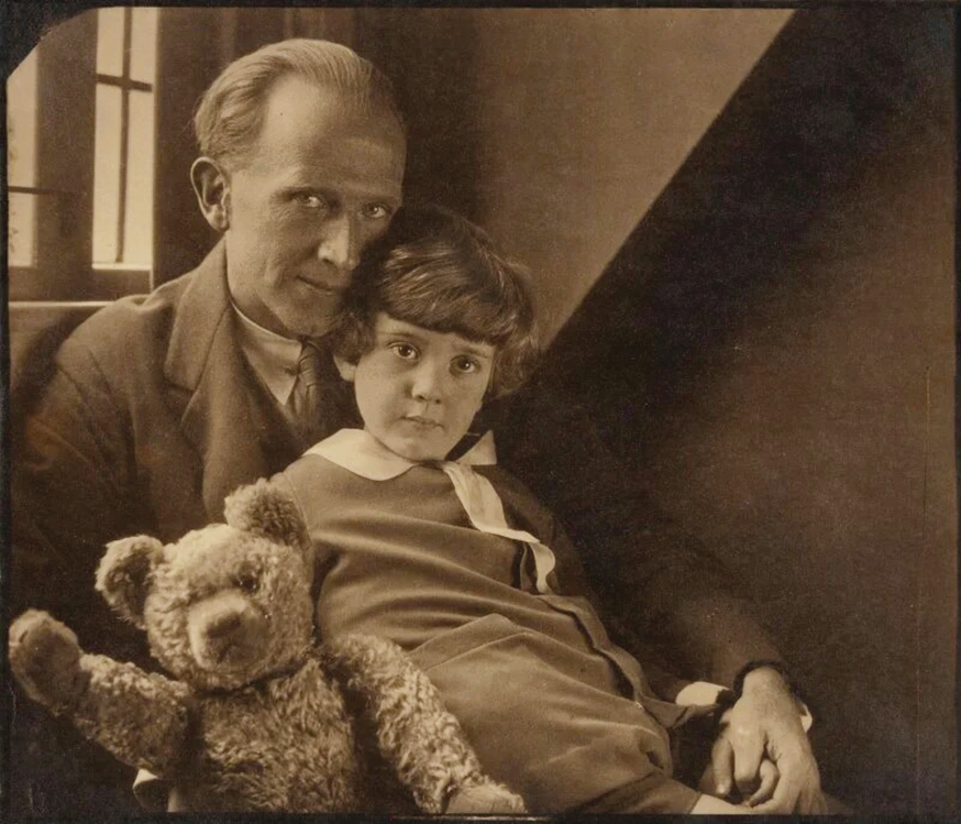 A. A. Milneʼas su sūnumi Christopheriu Robinu ir Mike Pūkuotuku. 1926 m. Howardo Costerio nuotr., šaltinis „Vikipedija“ A. A. Milneʼas su sūnumi Christopheriu Robinu ir Mike Pūkuotuku. 1926 m. Howardo Costerio nuotr., šaltinis „Vikipedija“